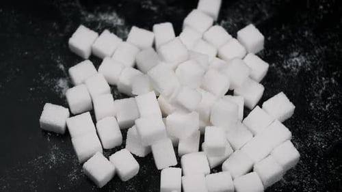 Many Sugar Cubes Rotate on a Black Background CloseUp