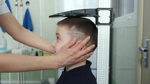 close-up of a boy having his height measured in a medical office