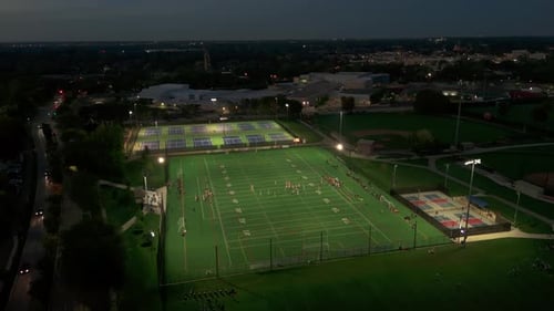Wide Aerial Shot of American Football Teams of Play at Night Time