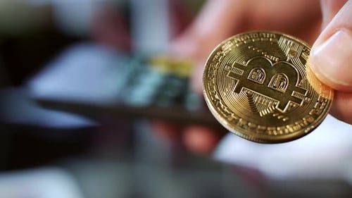 Close-Up of Cryptocurrency Coin Held in Fingers