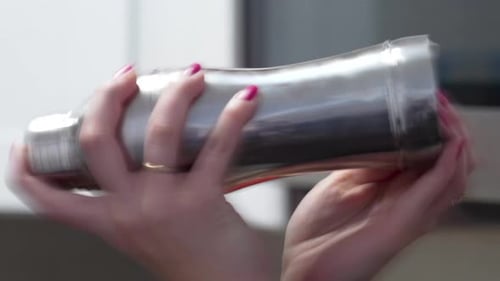 Woman Bartender Shakes Cobbler Cocktail Shaker Close Up of Hands with Silver Tin and Pink Nail Poli