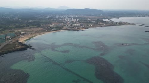 Drone aerial view in South Korea countryside flying over the ocean and green island small village is