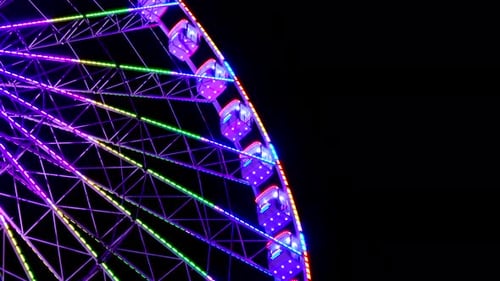Big amazing illuminated colorful spinning ferris wheel on background dark sky night. 4K.