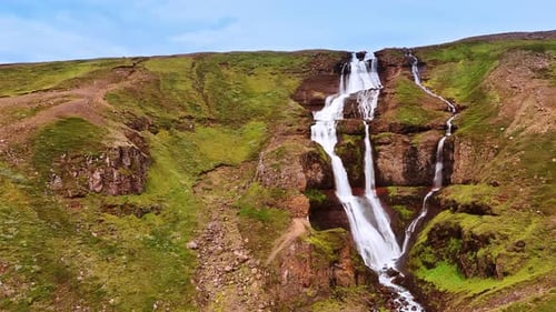 Cascada que se divide en tres arroyos que fluyen por la roca desnuda