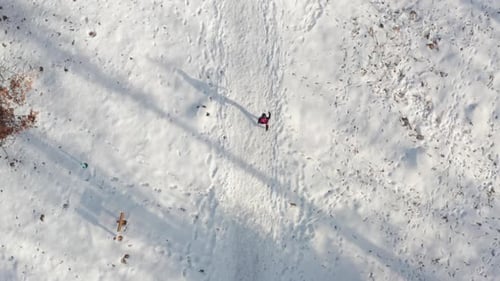 Vue aérienne de haut en bas, femme se promenant sur un sentier forestier enneigé