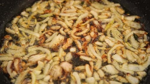 Crispy Fried Onion Bits with Oil in the Pan Deep Fried Onion Homemade Frying Onion in a Black