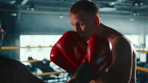 Emerging Boxer Engages in Intensive Training with Personal Coach in Gym