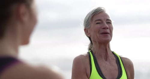 Senior woman talking with younger woman on beach