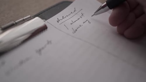Writing Down Achieved Tasks for Today Close Up