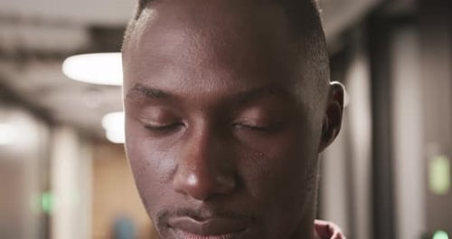 Close-up of serious businessman in office hallway, focusing on camera
