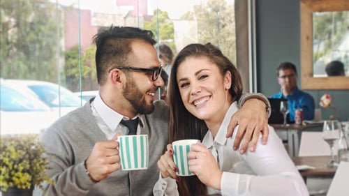 Affectionate couple enjoying coffee in urban cafe