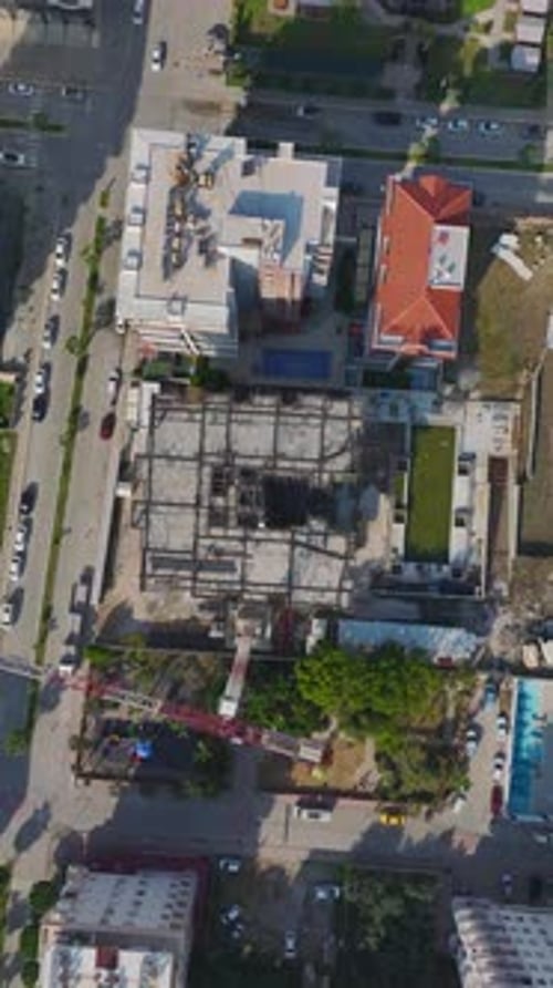 Vídeo vertical: trabajadores construyen paredes con herramientas de hormigón y una estructura metálica en un gran