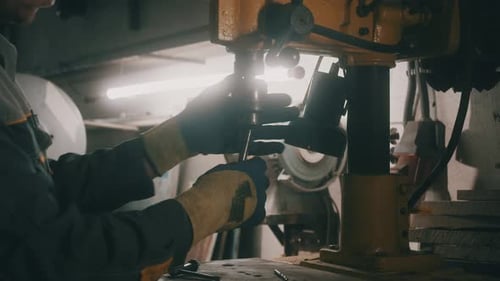 Ein Arbeiter arbeitet in einer Werkstatt an einer Metallbohrmaschine