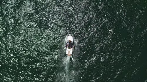 Speed boat with people roaring across the Sea at high speed