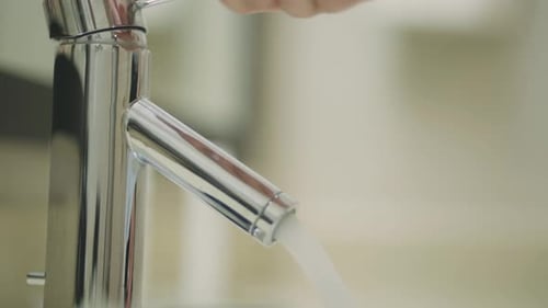 Close up of hand washing at bathroom sink