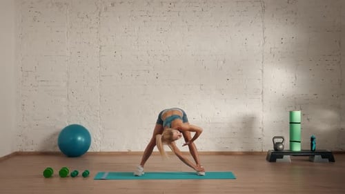 Athletic Woman Stretching on Yoga Mat Indoors