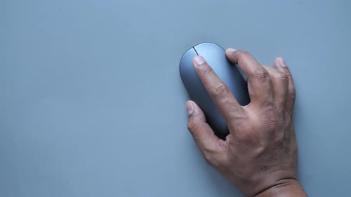 Hand Using Wireless Mouse on Gray Surface