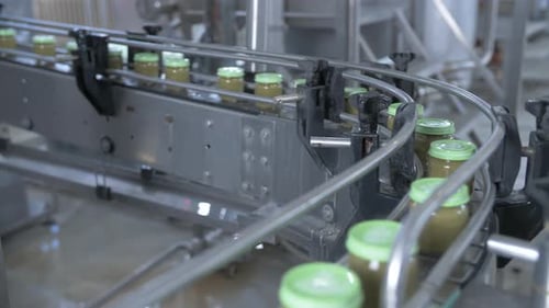 Glass Jars Move Along the Automatic Line of the Baby Food Production Plant