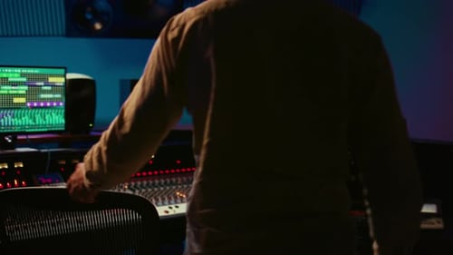 Sound Designer Recording Tunes to Create a New Song in Control Room