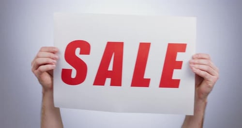 Sale, sign and hands with a poster, promotion and announcement of discount in studio with white