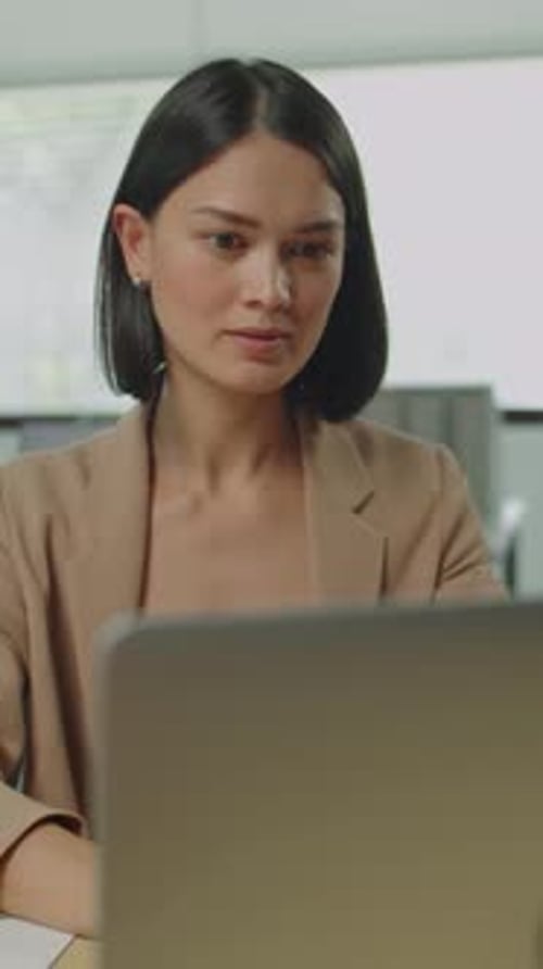 Young Woman Working at Laptop in Modern Office