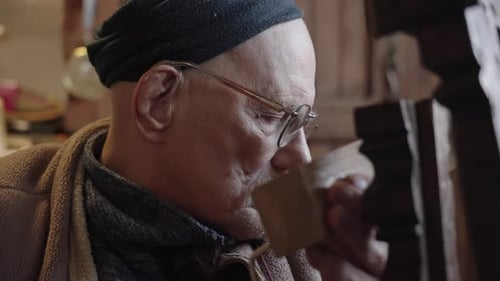 Elderly Male Master Works in His Workshop Restoring Furniture