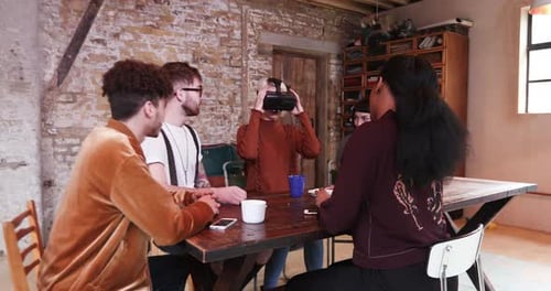 Young Adults Around Table Try Out VR Headset