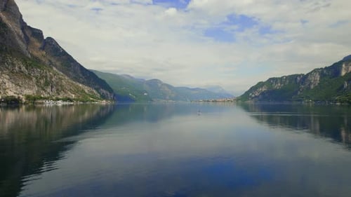 Young Man Paddle Boarding on Lake Como, in Italy, During Spring