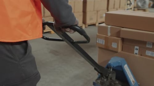 Warehouse Worker Moving Boxes with Pallet Jack
