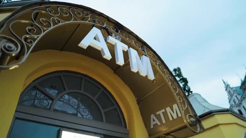 ATM Entrance Featuring Elegant Architecture Set Against a Clear Blue Sky in a Bustling Urban