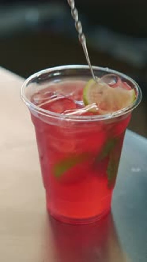 A Refreshingly Delicious Red Drink Featuring Mint and Lime As a Stylish and Appealing Garnish