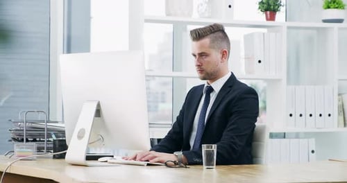 4k video footage of a young businessman working on a computer in an office