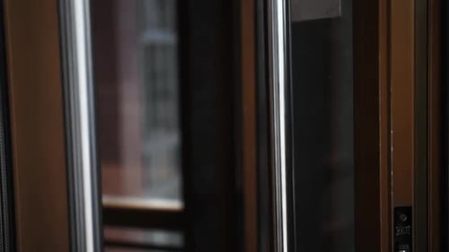 Man Opening Glass Door into Building