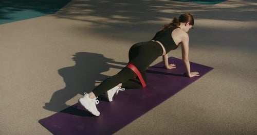 Woman Doing Leg Kickbacks with Resistance Band