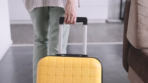 An Unrecognizable Woman with a Yellow Suitcase Arrived at the Rented Apartment