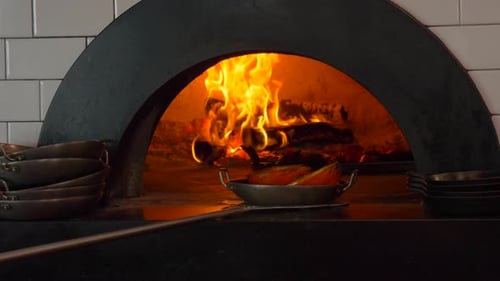 Wood fired oven burning flames in kitchen