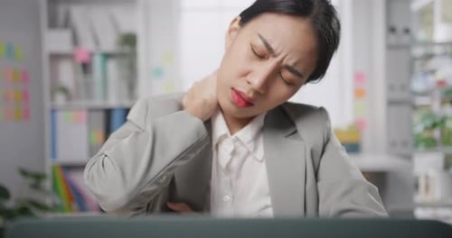 Woman Stretches Hands and Neck at Desk