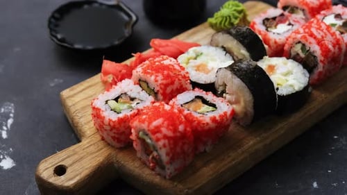 Vibrant Sushi Rolls on Wooden Board with Sauces