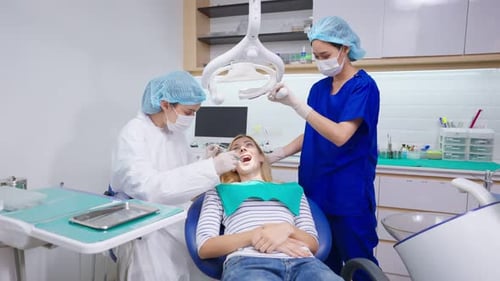 Female dentist examine tooth to Caucasian girl at dental health clinic.