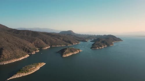 Aerial drone flying over a lake, water dam, with mountains at sunrise. Beautifull dreamy landscape v