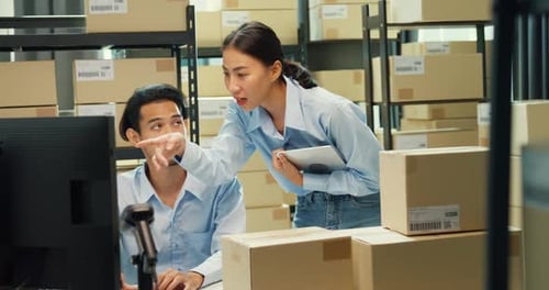 Asian man and lady computer and barcode machine scanner discuss stock detail customer online.