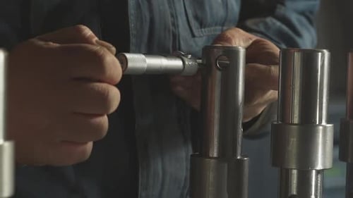 Worker Connects Detail to Metal Cylinder Assembling Machine