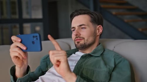Man Using Smartphone Casually at Home on Couch