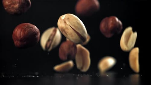 A Variety of Nuts Fall on the Table Filmed on a Highspeed Camera at 1000 Fps
