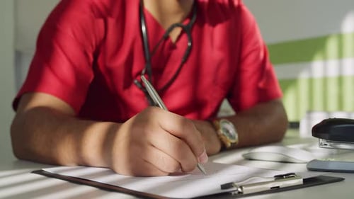 Medical Professional Writing on a Clipboard