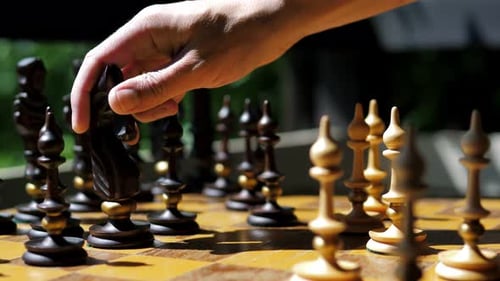 Schach in der Natur unter der Sonne Mann spielt Schachspiel aus nächster Nähe Selbstbewusster Geschäftsmann