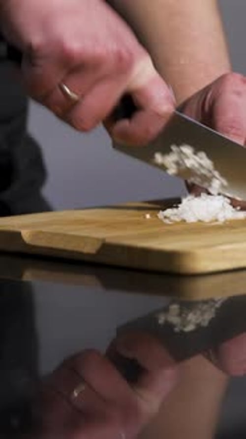 Close Up of Man Hands Cutting White Onion on a Wooden Chopping Board with a Kitchen Knife Art