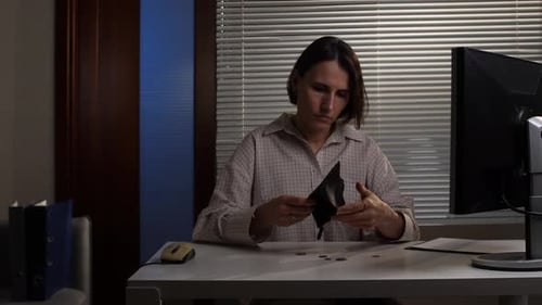 Woman Feeling Stressed and Anxious Looking Inside an Empty Wallet at Her Office Desk Representing