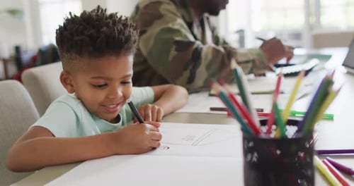 Cute Child Drawing with Father at Table
