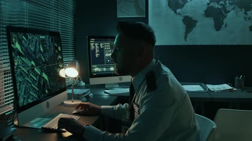 Man Working Late on Computers in Dark Office